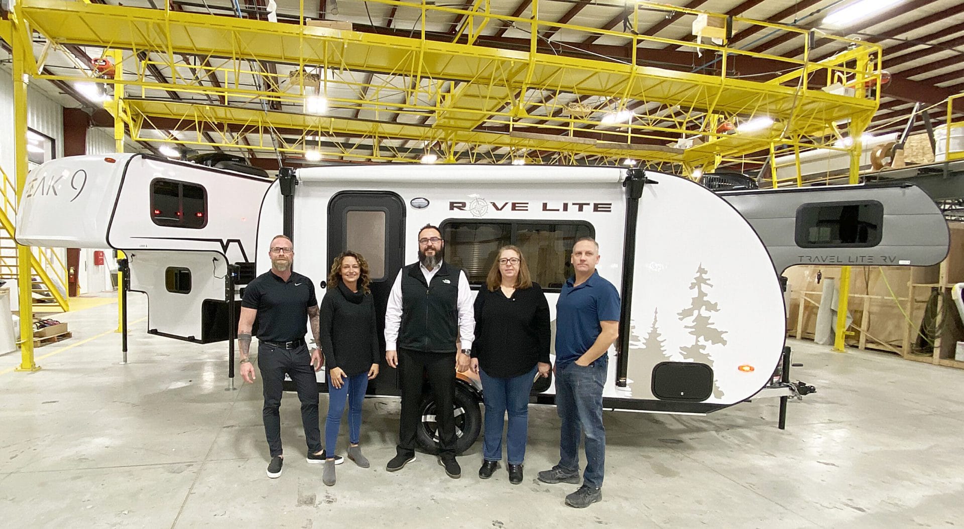 Travel Lite COO and General Manager Ryan Rebar (L) poses in front of the new Rove Lite with team members 