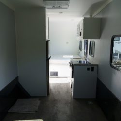 Interior of an ATC fiber optic splicing trailer with laminated counters, aluminum cabinets, LED lighting, and climate control systems.